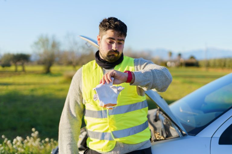 Man in safety vest checking his watch for time